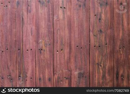 Grungy red paintwork on a wooden panel