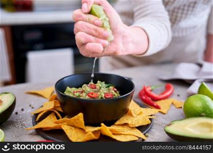 Guacamole dip with tortilla chips or nachos on black serving board.. Guacamole dip with tortilla chips or nachos on black serving board