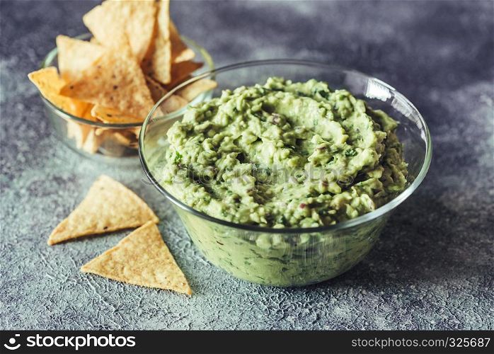 Guacamole in the glass bowl with tortilla chips