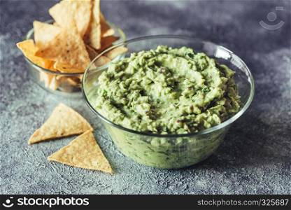 Guacamole in the glass bowl with tortilla chips