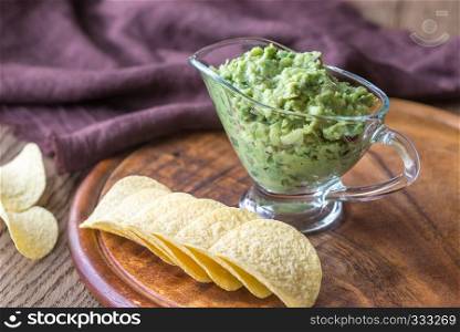 Guacamole with chips on the wooden board
