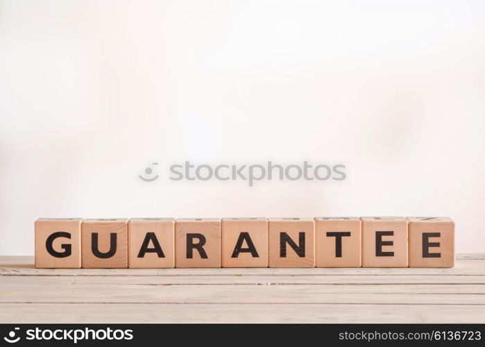 Guarantee sign made of blocks on a wooden desk