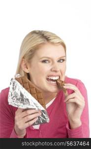 Guilty Looking Young Woman Eating Big Bar Of Chocolate In Studio