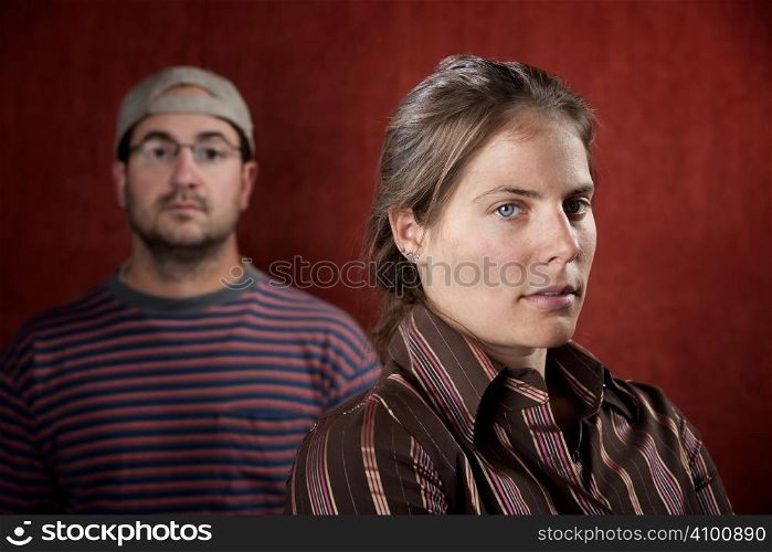 Guilty woman with upset man in the background