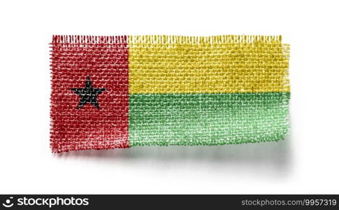 Guinea Bissau flag on a piece of cloth on a white background.. Guinea Bissau flag on a piece of cloth on a white background