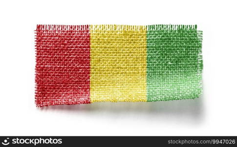 Guinea flag on a piece of cloth on a white background.. Guinea flag on a piece of cloth on a white background