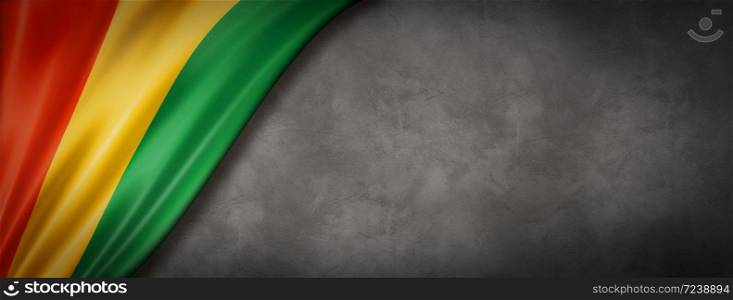 Guinea flag on concrete wall. Horizontal panoramic banner. 3D illustration. Guinean flag on concrete wall banner