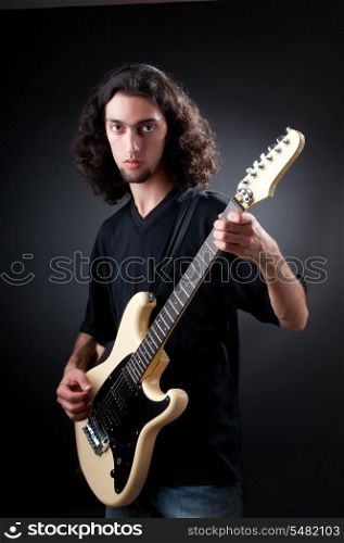 Guitar player against the dark background