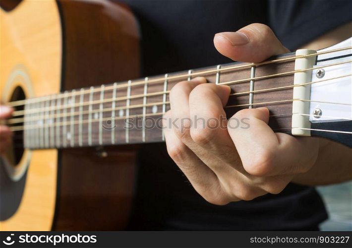 Guitar Player Hand or Musician Hand in C Major Chord on Acoustic Guitar String with soft natural light in side view