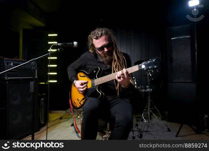 Guitarist man plays an electric guitar Close-up at studio.. Guitarist man plays an electric guitar Close-up at studio