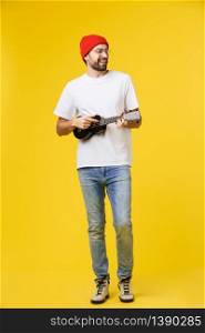 Guitarist man plays on the electric guitar with bright emotions, isolated on yellow background. Guitarist man plays on the electric guitar with bright emotions, isolated on yellow background.