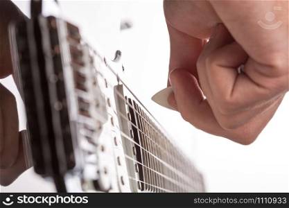 Guitarist plays on stage. Focus on pick in hand