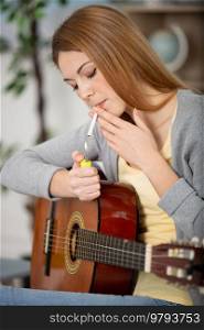 guitarist woman lighing up a cigarette