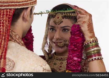 Gujarati bride putting a garland on a groom