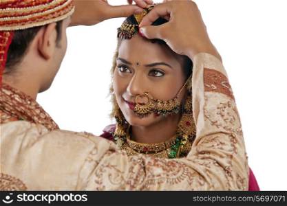 Gujarati groom putting sindoor on brides forehead