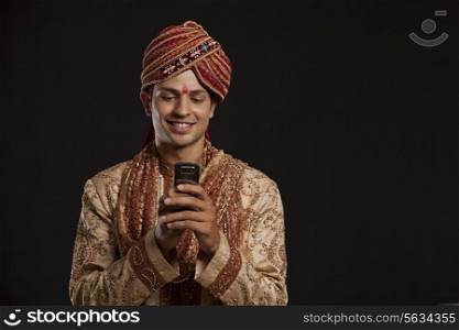 Gujarati groom reading an sms