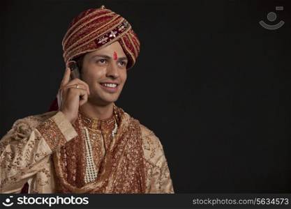Gujarati groom talking on a mobile phone
