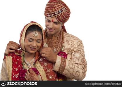 Gujarati groom tying a mangal sutra around brides neck