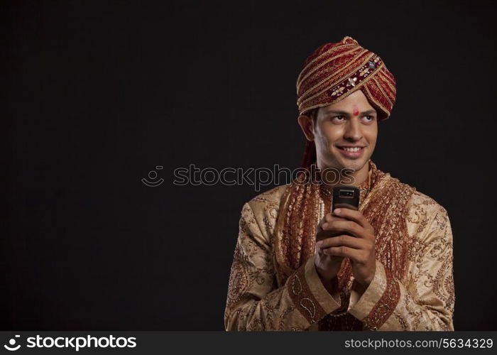 Gujarati groom with a mobile phone