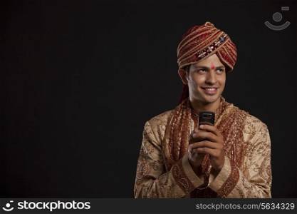 Gujarati groom with a mobile phone