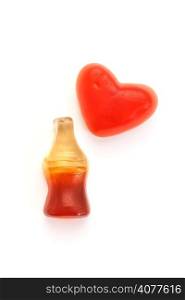 Gummy cola bottles and heart candy on white background