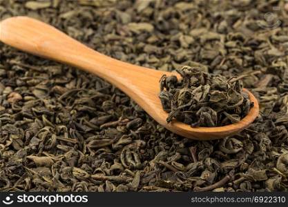 Gunpowder green tea in spoon closeup photo for background