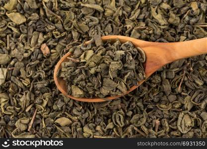 Gunpowder green tea in spoon closeup photo for background