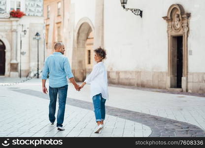 guy and a girl happily walk in the morning on the empty streets of old Europe