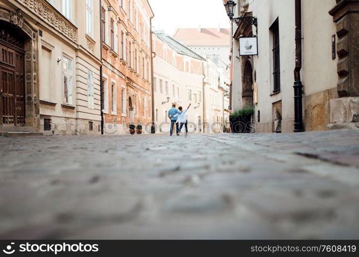 guy and a girl happily walk in the morning on the empty streets of old Europe