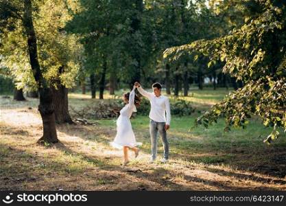 guy and a girl walk along the paths of a forest park between tall trees