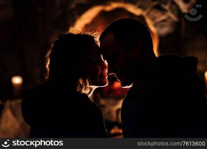 guy and girl are sitting in a wooden house on the background of a burning fireplace