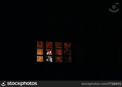 guy and girl are sitting in a wooden house on the background of a burning fireplace