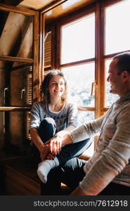 guy and girl in the house near the window overlooking a snowy landscape