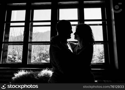 guy and girl in the house near the window overlooking a snowy landscape