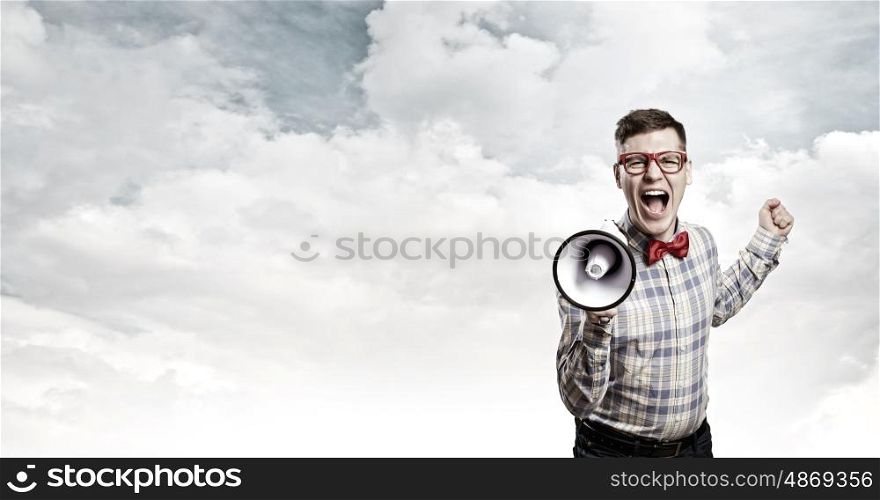 Guy announcing something. Young funny man screaming emotionally in megaphone