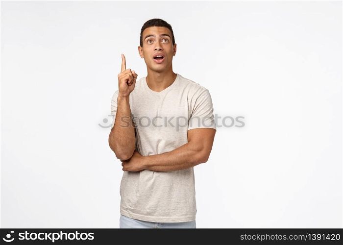 Guy finally got excellent idea after pondering. Handsome muscular hispanic guy in casual t-shirt, raising one finger up and open mouth to speak-out suggestion, have plan, remember something.. Guy finally got excellent idea after pondering. Handsome muscular hispanic guy in casual t-shirt, raising one finger up and open mouth to speak-out suggestion, have plan, remember something