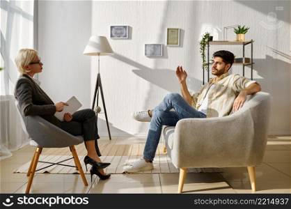 Guy gesturing hand explaining something talk to doctor psychologist. Therapist listening carefully. Emotional guy gesturing talking to doctor psychologist