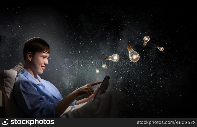 Guy in bed. Young teenager guy in bed using tablet pc