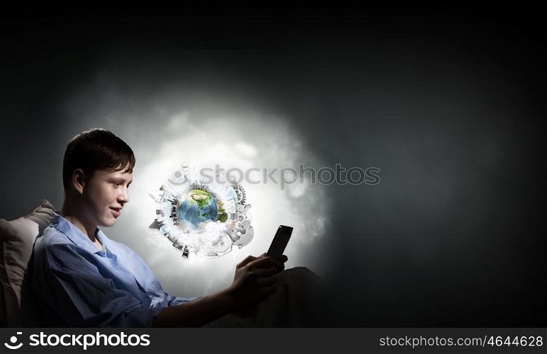 Guy in bed. Young teenager guy in bed using tablet pc. Elements of this image are furnished by NASA