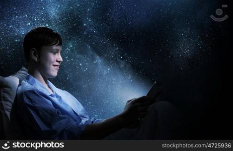 Guy in bed. Young teenager guy in bed using tablet pc