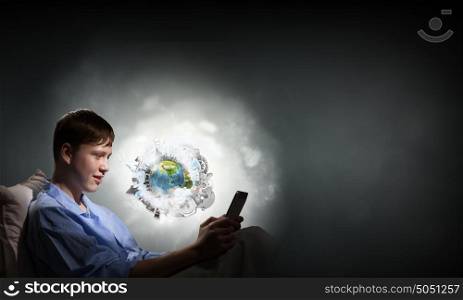 Guy in bed. Young teenager guy in bed using tablet pc. Elements of this image are furnished by NASA