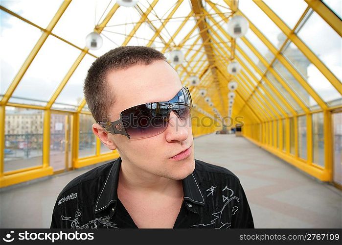 guy in sunglasses on yellow footbridge