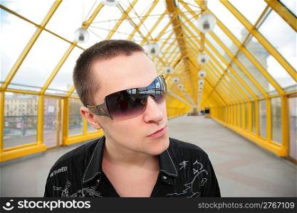 guy in sunglasses on yellow footbridge
