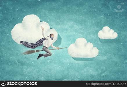 Guy on broom. Young businessman flying on broom high in sky