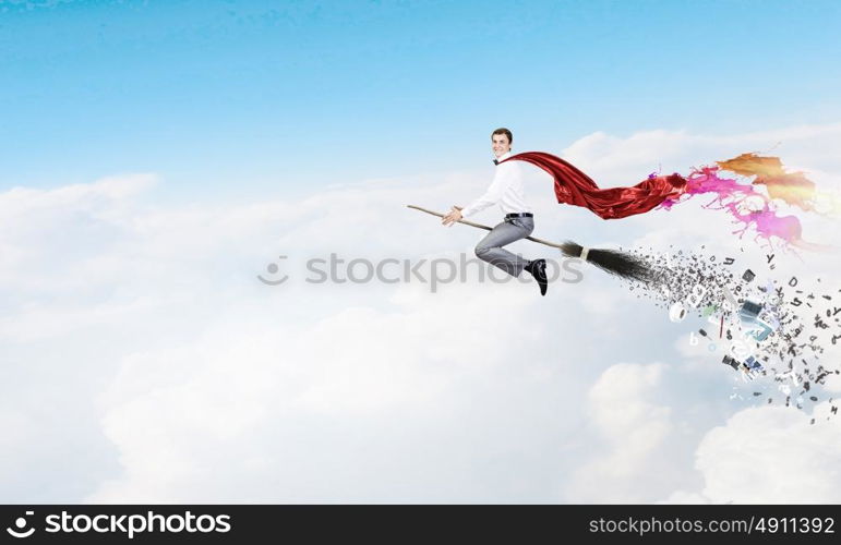 Guy on broom. Young businessman flying on broom high in sky