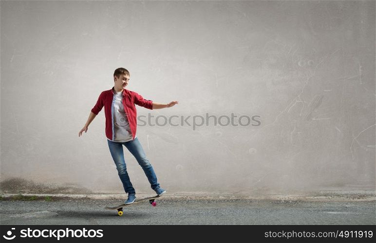 Guy on skateboard. Handsome teenager cool acive boy riding skateboard