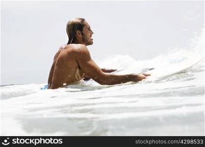 Guy on surfboard waiting for wave
