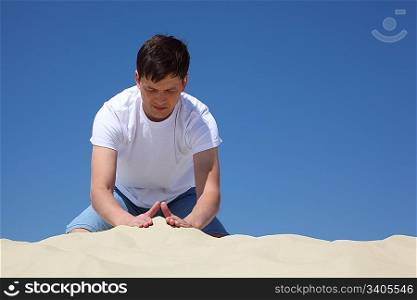 guy plays in sand against blue sky