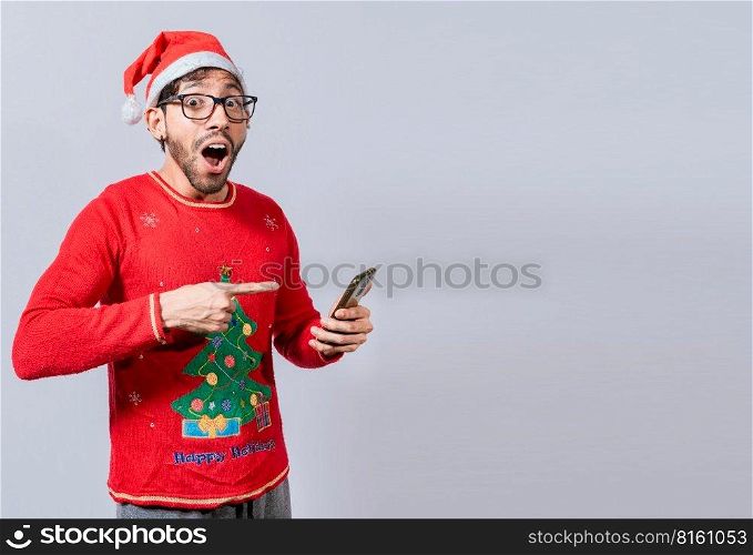 Guy pointing at christmas promotion on phone. Online Christmas special offers concept, amazed people pointing at a Christmas promotion on phone, Amazed man pointing at christmas offer online