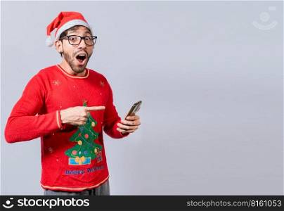 Guy pointing at christmas promotion on phone. Online Christmas special offers concept, amazed people pointing at a Christmas promotion on phone, Amazed man pointing at christmas offer online